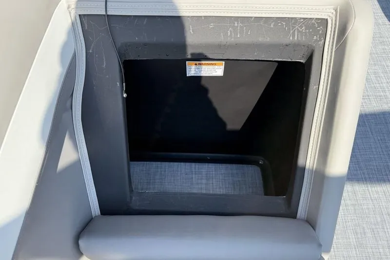 Slide: The Image of Storage compartment on 2026 Premier 220 Sunscape RF boat, featuring a warning label. - 24
