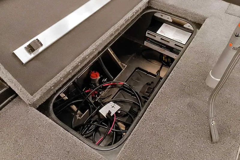 Slide: The Image of 2026 Ranger RT188P boat battery compartment with wiring and storage. - 25