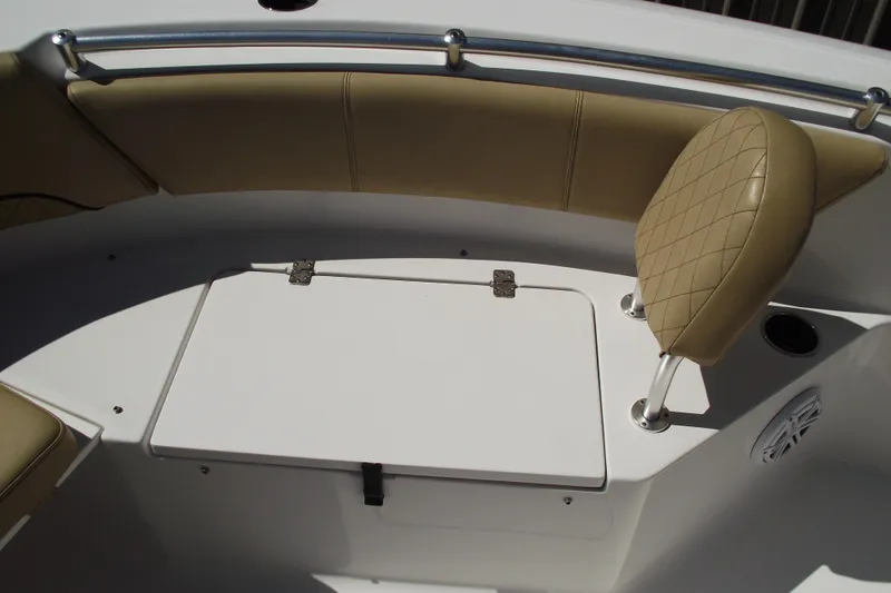Slide: The Image of 2022 Sportsman Open 232 Center Console boat interior with tan seating and storage compartment. - 12
