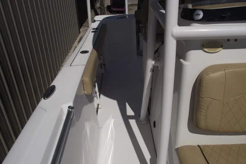 Slide: The Image of 2022 Sportsman Open 232 Center Console boat interior with beige seating and white deck. - 17