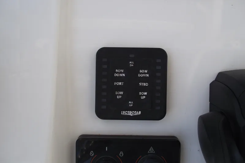 Slide: The Image of Control panel on 2022 Sportsman Open 232 Center Console boat, featuring Lectrotab trim tab switches. - 24