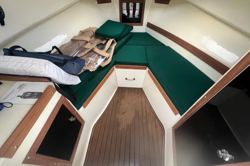 Slide: The Image of 2018 Seaway 21 Seafarer Cuddy interior with green cushions and wooden accents. - 5