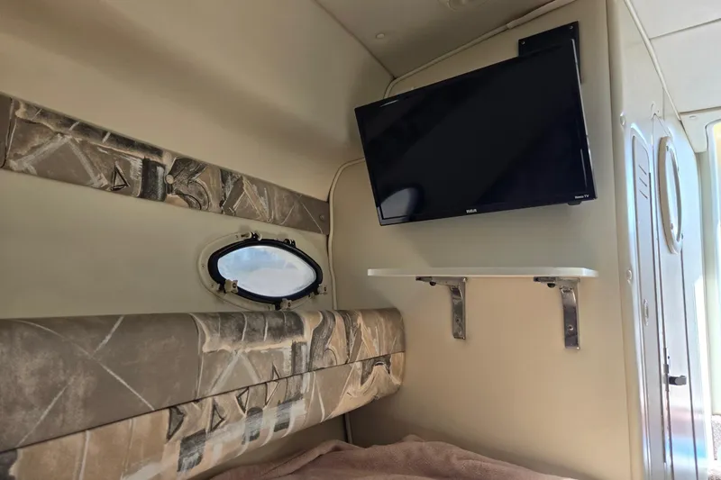 Slide: The Image of Interior of 2000 Rinker 270 Fiesta Vee with TV and porthole window. - 16