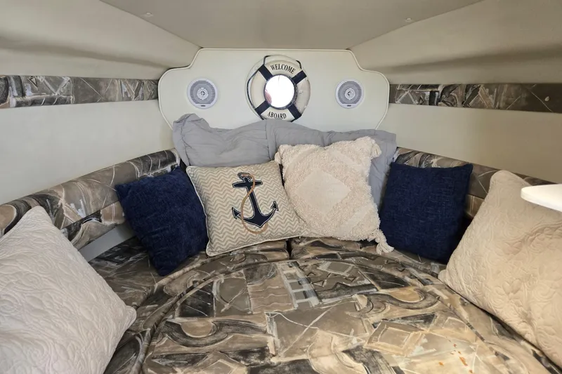 Slide: The Image of Cozy cabin interior of 2000 Rinker 270 Fiesta Vee with nautical-themed pillows. - 19