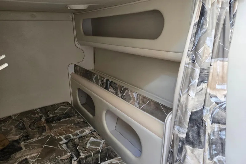 Slide: The Image of Interior cabin of 2000 Rinker 270 Fiesta Vee with patterned upholstery and storage compartments. - 21