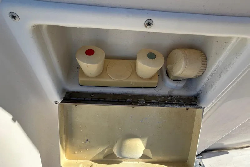 Slide: The Image of Control panel on a 2000 Rinker 270 Fiesta Vee boat, featuring knobs and switches. - 24