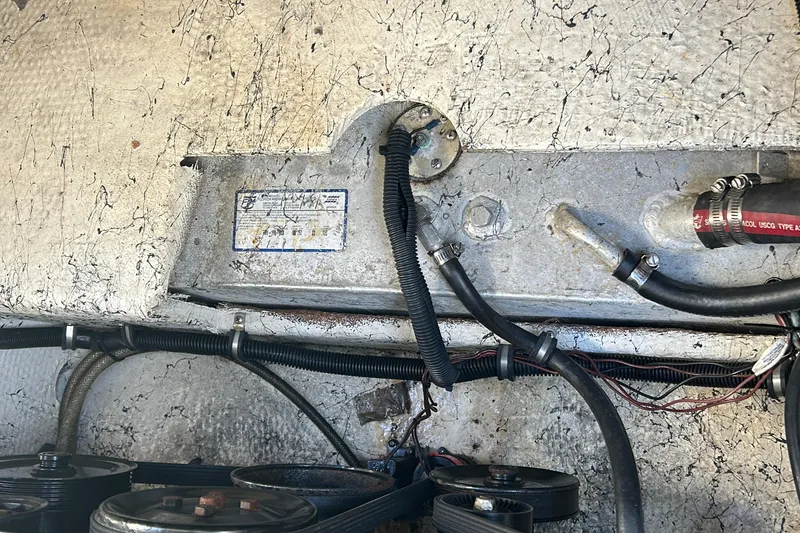 Slide: The Image of Engine compartment of a 2000 Rinker 270 Fiesta Vee boat, showing wiring and hoses. - 38