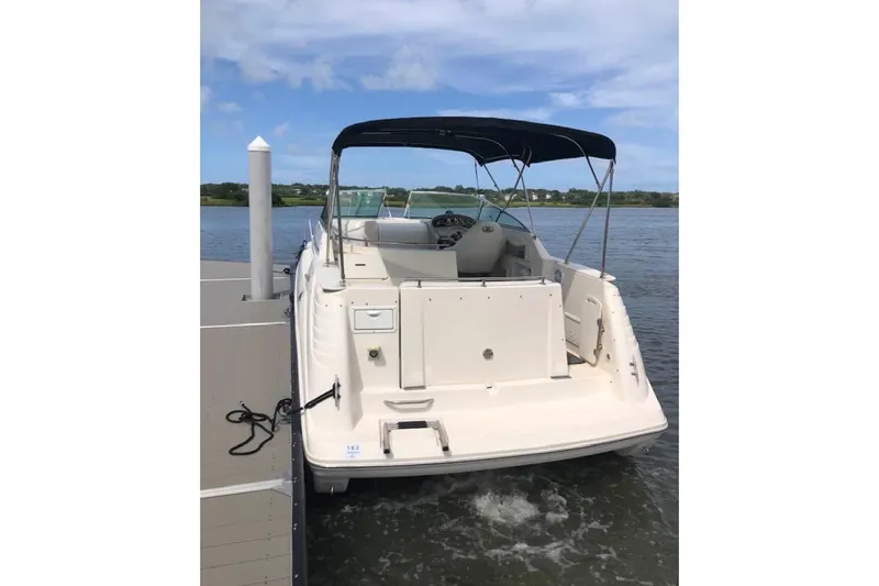 Slide: The Image of 2000 Rinker 270 Fiesta Vee boat docked on calm water under a clear sky. - 40
