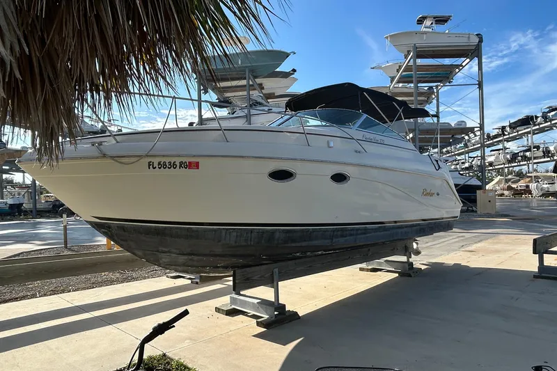 Slide: The Image of 2000 Rinker 270 Fiesta Vee boat on dry dock, surrounded by other boats. - 8