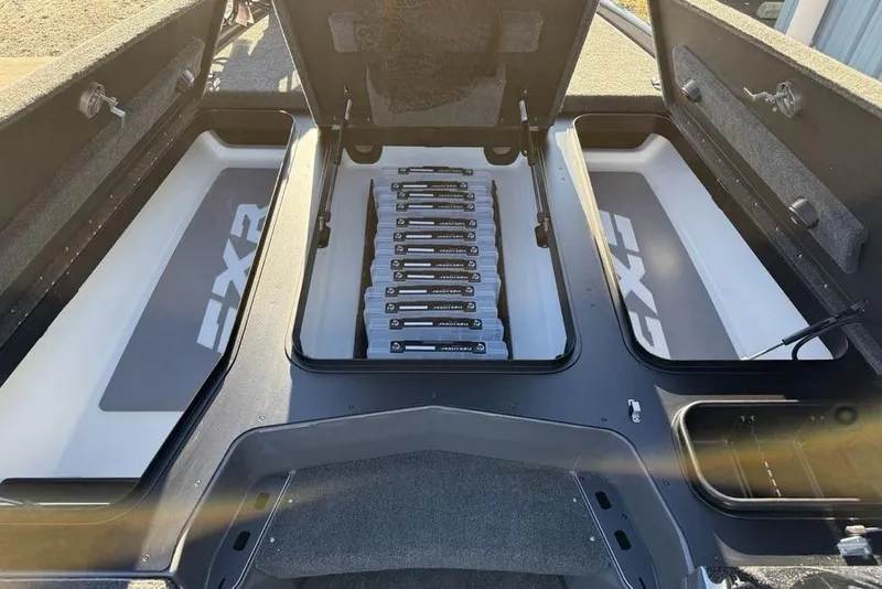 Slide: The Image of 2026 Skeeter FXR20 Apex boat storage compartments with organized tackle boxes. - 13