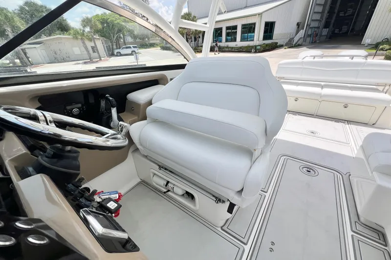 Slide: The Image of 2019 Robalo R317 Dual Console boat interior with white seating and steering wheel. - 11