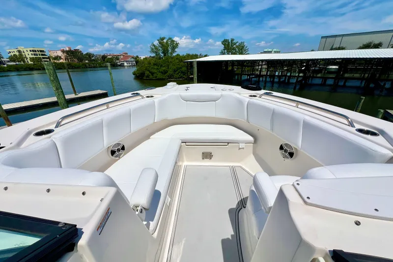 Slide: The Image of 2019 Robalo R317 Dual Console boat with spacious seating, docked by a scenic waterfront. - 12