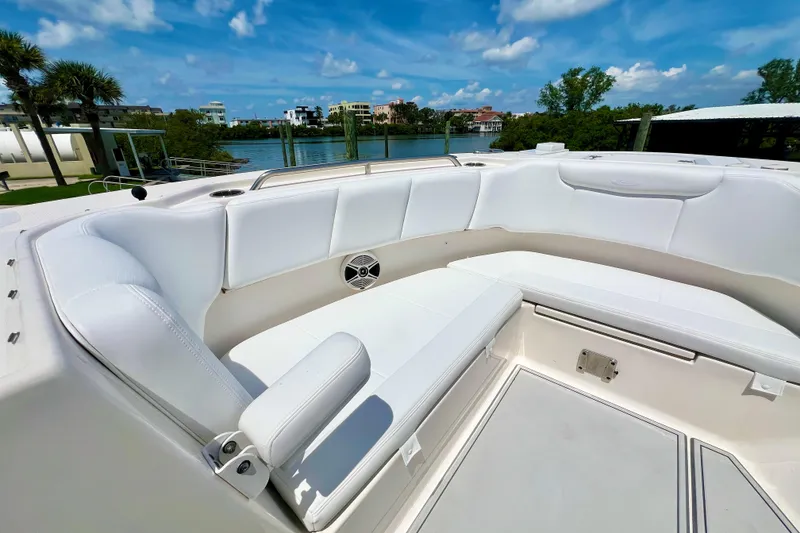 Slide: The Image of 2019 Robalo R317 Dual Console boat with white seating, docked by a scenic waterfront. - 13