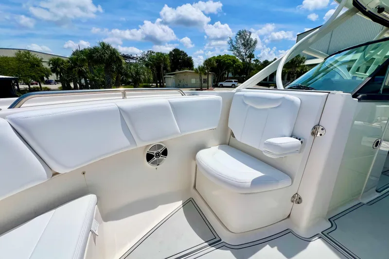 Slide: The Image of 2019 Robalo R317 Dual Console boat interior with white seating and speaker. - 14
