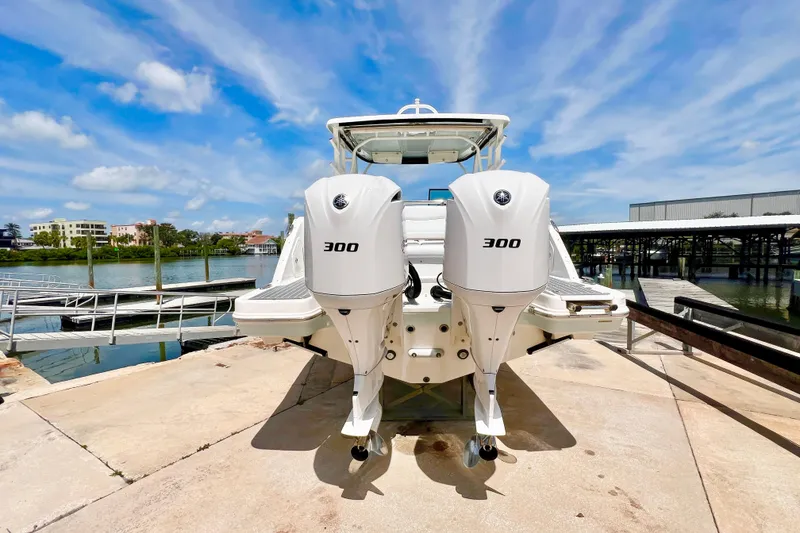 Slide: The Image of 2019 Robalo R317 Dual Console boat with twin 300 horsepower engines at a marina. - 2