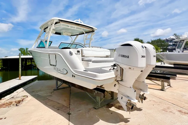Slide: The Image of 2019 Robalo R317 Dual Console boat with twin Yamaha 300 engines on a sunny dock. - 3
