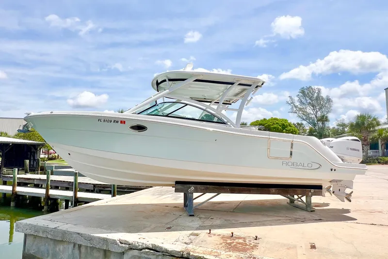 Slide: The Image of 2019 Robalo R317 Dual Console boat on a dock under a clear blue sky. - 4