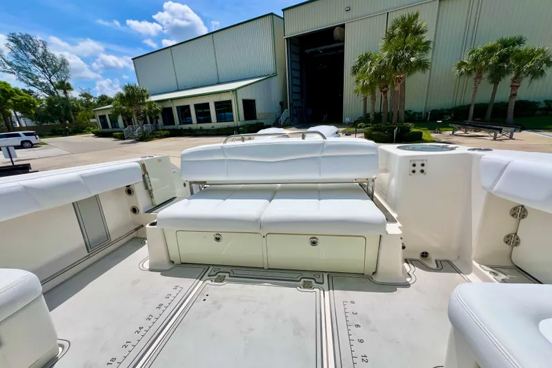 Slide: The Image of 2019 Robalo R317 Dual Console boat with white seating, docked near a building. - 7