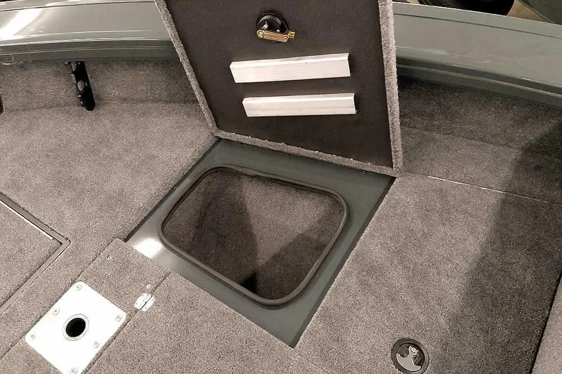 Slide: The Image of 2026 Ranger VX1988 WT boat interior with open storage compartment and carpeted flooring. - 15