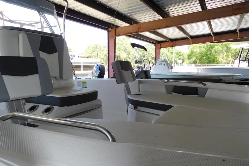 Slide: The Image of 2025 Robalo 206 Cayman boat interior under a metal roof, showcasing seating and console. - 3