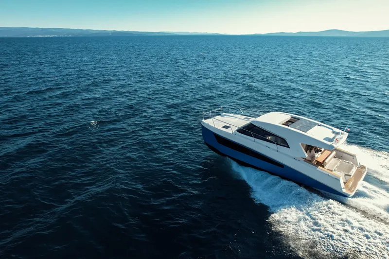 Slide: The Image of 2025 Makai M37 yacht cruising on open sea under clear blue sky. - 1