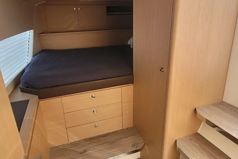 Slide: The Image of Cozy cabin interior of 2025 Makai M37 with wooden finish and comfortable bedding. - 10