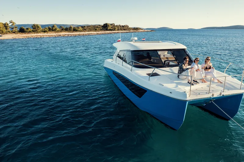 Slide: The Image of 2025 Makai M37 yacht with three people enjoying a sunny day on the water. - 100