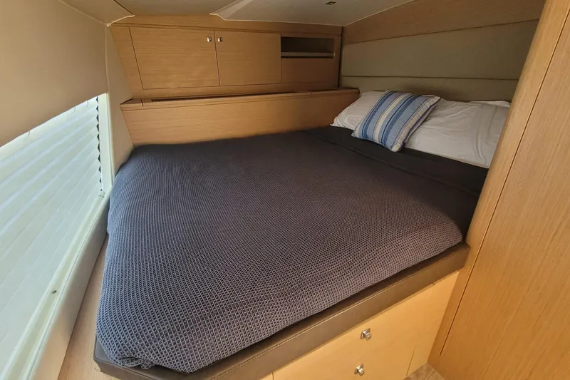 Slide: The Image of Cozy cabin bed in 2025 Makai M37 yacht with wooden cabinetry and striped pillow. - 11