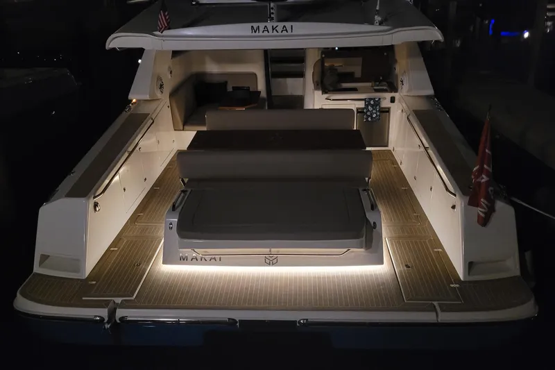 Slide: The Image of Sleek 2025 Makai M37 yacht with illuminated deck and modern seating at night. - 16