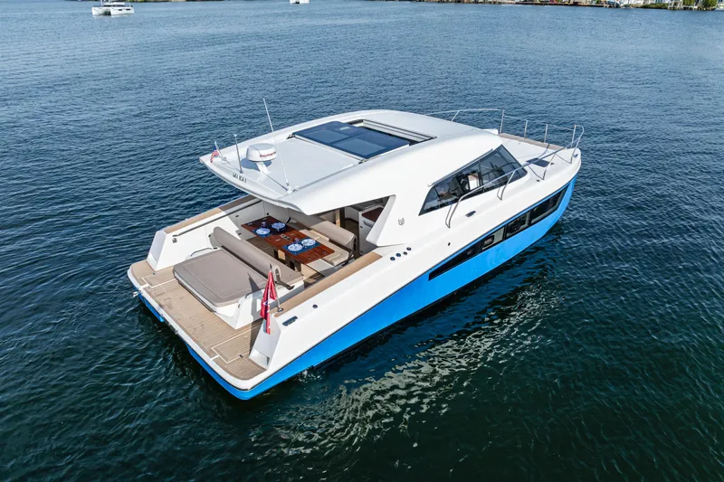 Slide: The Image of 2025 Makai M37 yacht on calm water, featuring sleek design and spacious deck. - 23