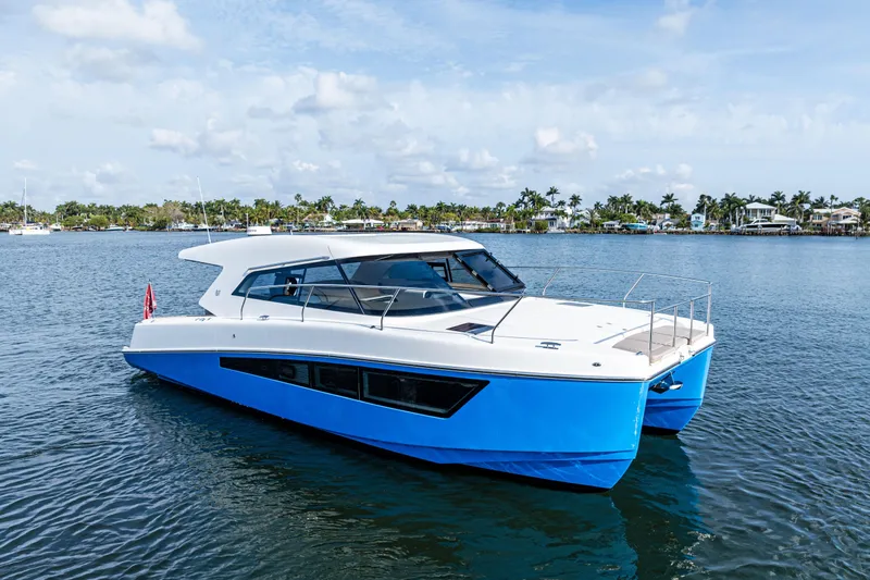 Slide: The Image of 2025 Makai M37 catamaran with sleek design, cruising on calm waters under a clear sky. - 26