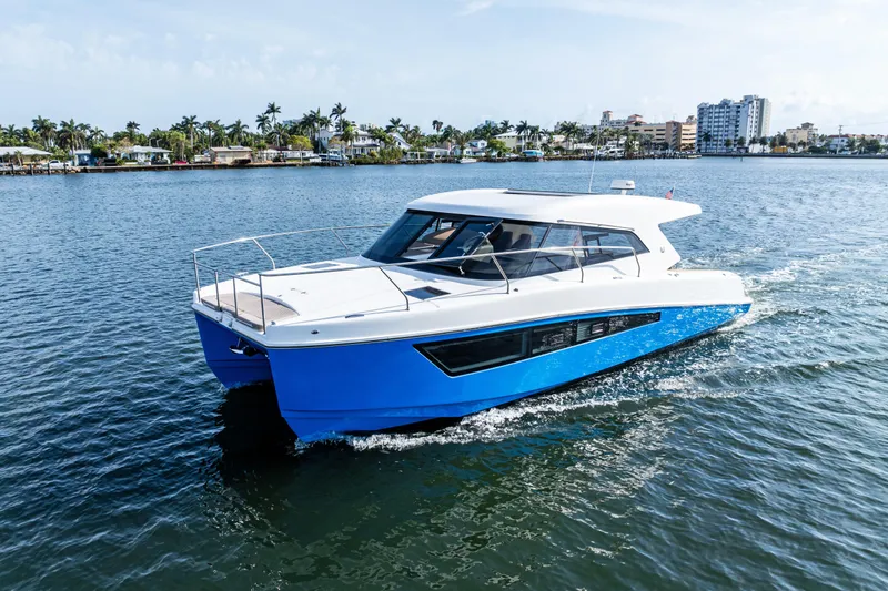 Slide: The Image of 2025 Makai M37 boat cruising on a sunny day near a coastal city. - 31