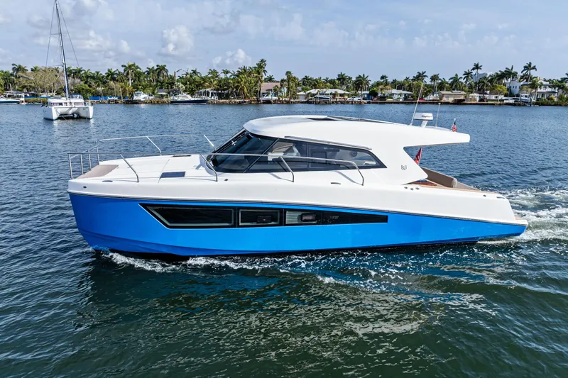 Slide: The Image of 2025 Makai M37 yacht cruising on a sunny day, blue and white design. - 32