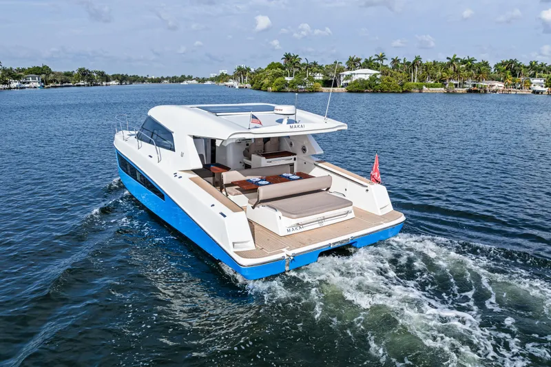 Slide: The Image of 2025 Makai M37 yacht cruising on a scenic waterway with lush greenery. - 33