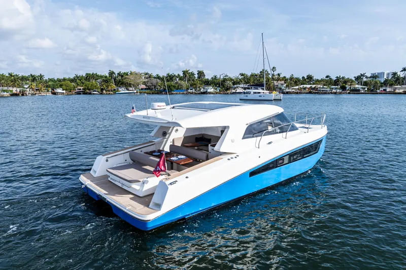 Slide: The Image of 2025 Makai M37 yacht cruising on a serene waterway with lush greenery in the background. - 34
