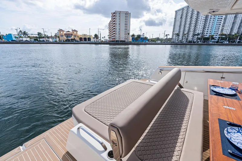 Slide: The Image of Luxury Makai M37 yacht deck with elegant seating, overlooking waterfront cityscape, 2025 model. - 35