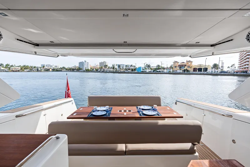Slide: The Image of Luxury Makai M37 yacht interior with elegant dining setup, overlooking serene waterfront view. - 36