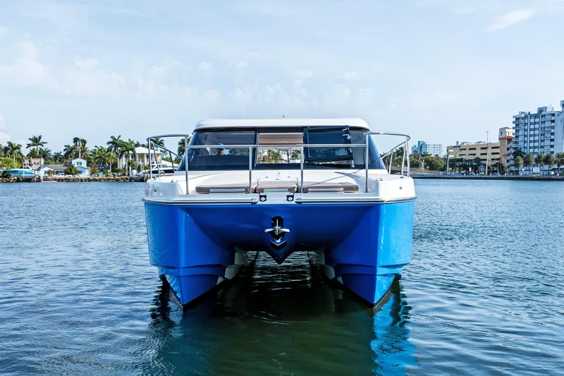 Slide: The Image of Front view of 2025 Makai M37 catamaran on calm water, urban skyline in background. - 4