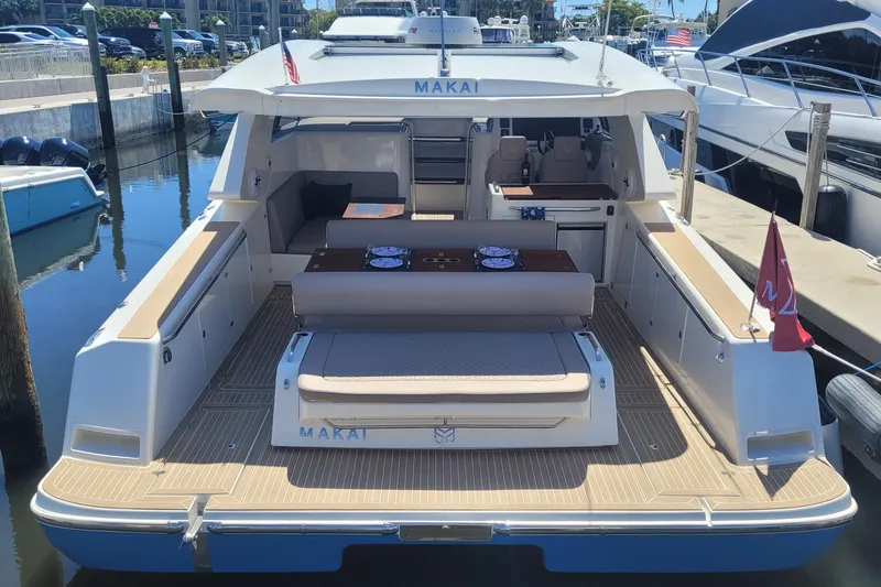 Slide: The Image of 2025 Makai M37 yacht docked, featuring spacious deck and seating area. - 5
