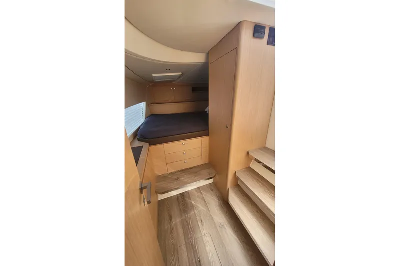 Slide: The Image of 2025 Makai M37 interior cabin with wooden finish and cozy bed setup. - 83