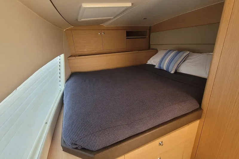 Slide: The Image of Cozy cabin interior of 2025 Makai M37 with comfortable bedding and wooden storage. - 85