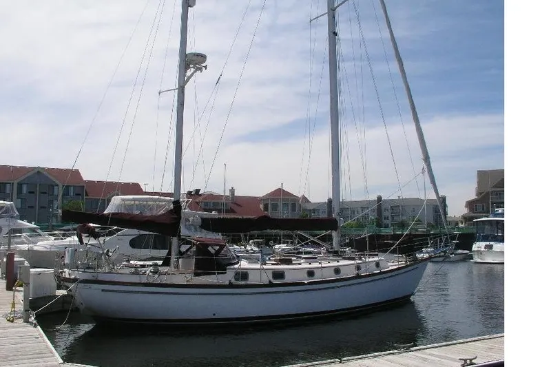 The Image of 1985 Shannon 43 Ketch sailboat docked at marina, clear sky background. - 0