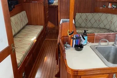 Slide: The Image of 1985 Shannon 43 Ketch interior with wood finish, seating, and kitchenette. - 3