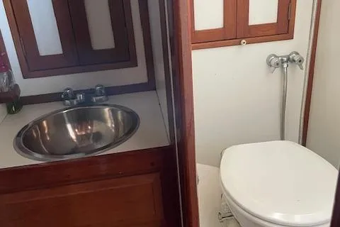 Slide: The Image of 1985 Shannon 43 Ketch bathroom with sink and toilet, wooden cabinetry. - 4