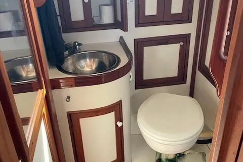 Slide: The Image of 1985 Shannon 43 Ketch bathroom with sink, toilet, and wooden cabinetry. - 5