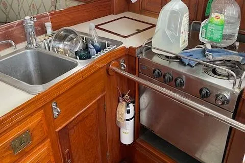 Slide: The Image of 1985 Shannon 43 Ketch kitchen with sink, stove, and wooden cabinetry. - 8