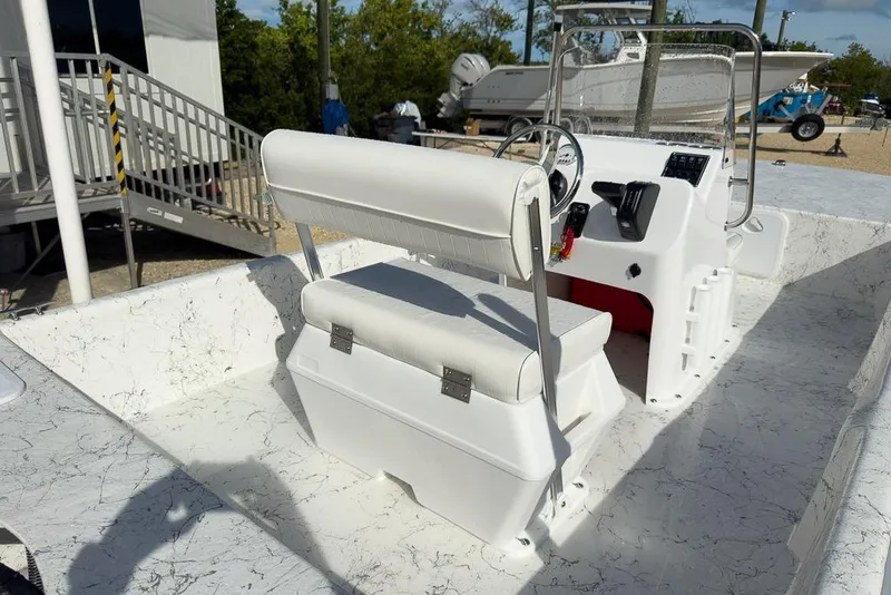 Slide: The Image of 2026 Coastal Skiff 171 boat interior with white seating and steering console. - 7