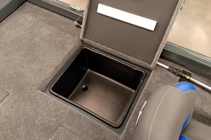 Slide: The Image of 2026 Ranger RT198P Fishing Package storage compartment with open lid and carpeted interior. - 28