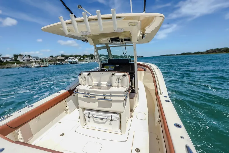Slide: The Image of 2017 Scout 300 LXF boat cruising on clear blue water under a sunny sky. - 12