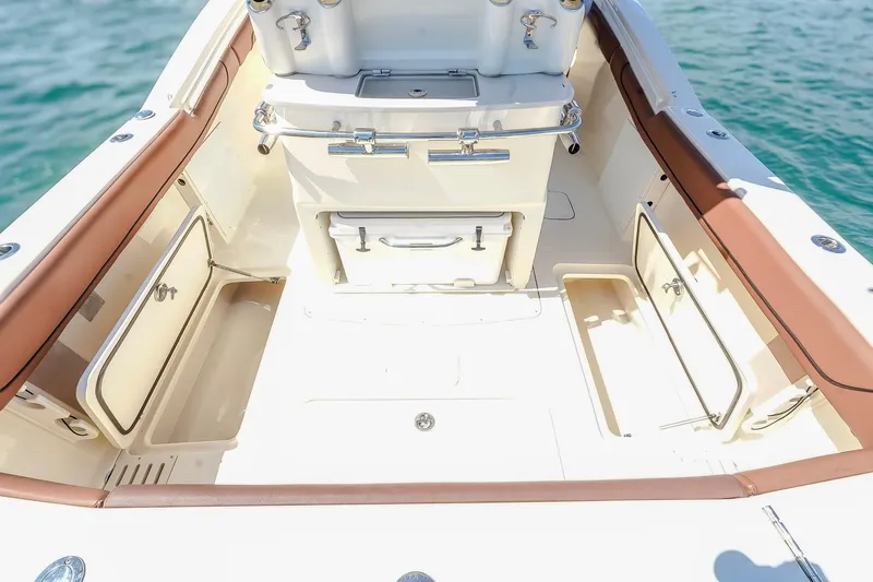 Slide: The Image of 2017 Scout 300 LXF boat interior with storage compartments and seating, on calm water. - 16